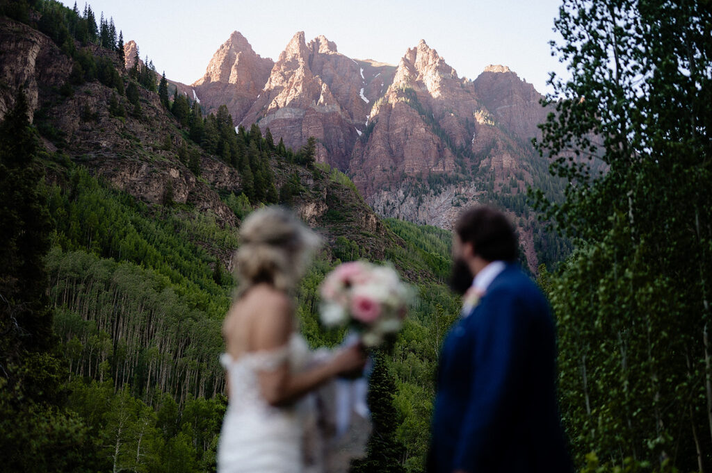 bride and groom looking at Maroon Bells mountains during their wedding