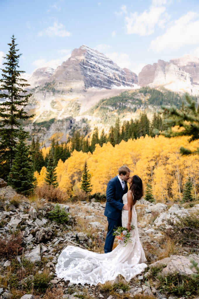 a man and woman kissing in front of mountains